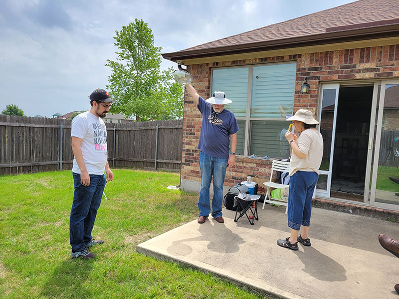 Paul and his parents observing the eclipse through a collander