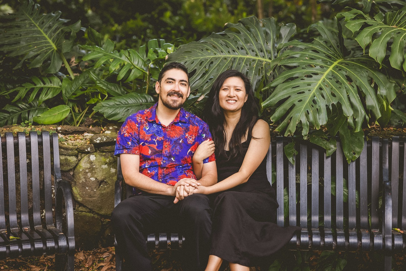 Paul and Jessie sitting on a bench near monstera plants