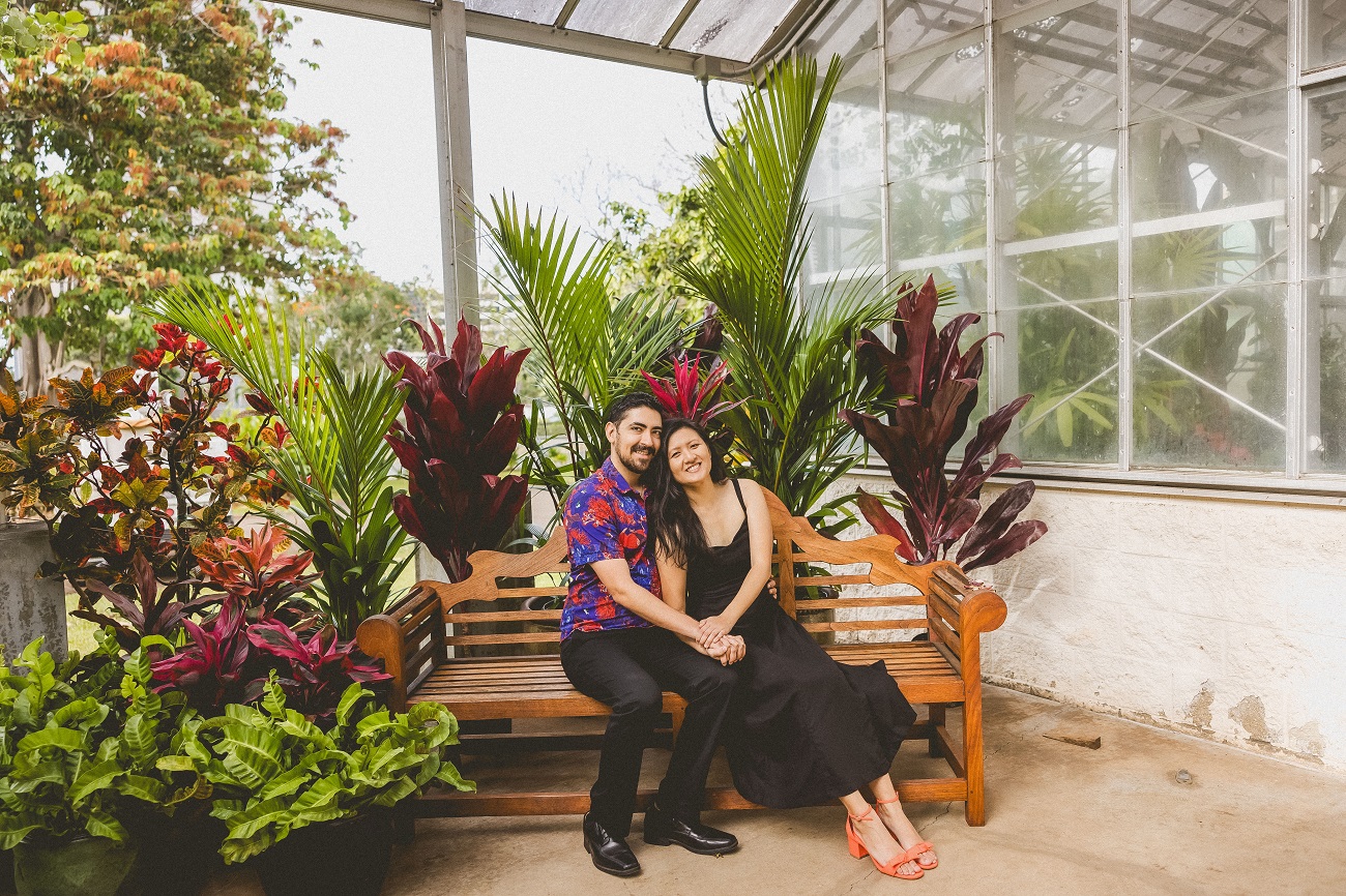 Paul and Jessie sitting on a bench by a greenhouse
