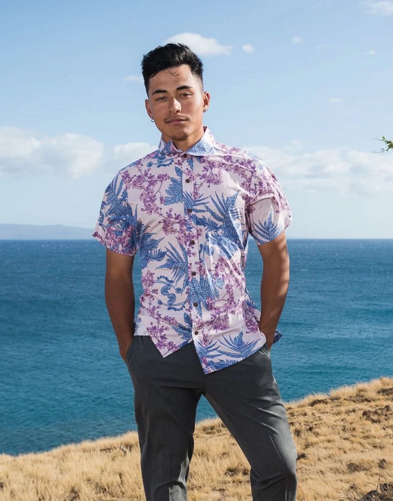 a man by the ocean wearing an aloha shirt and slacks