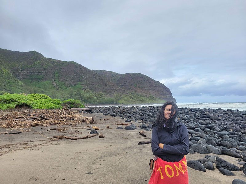 Jessie standing on a rocky beach on Molokai