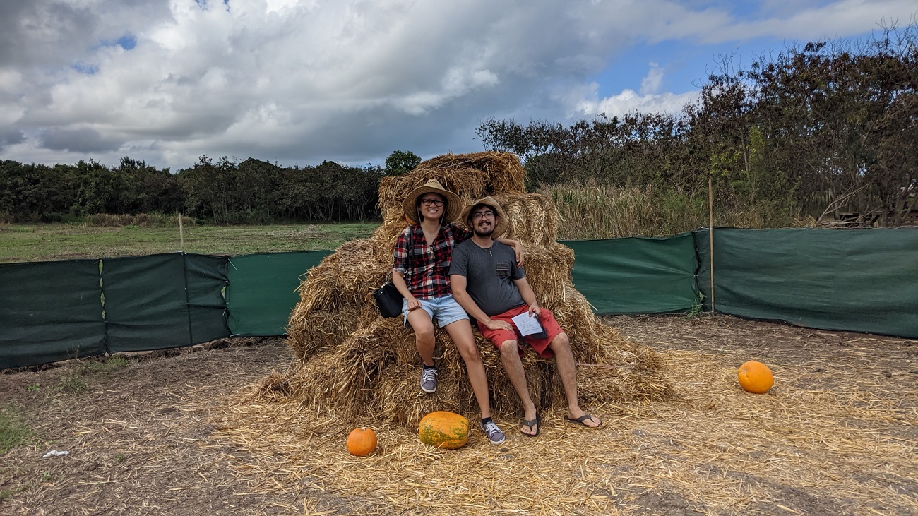 Paul and Jessie sitting on stacks of hay with pumpkins
