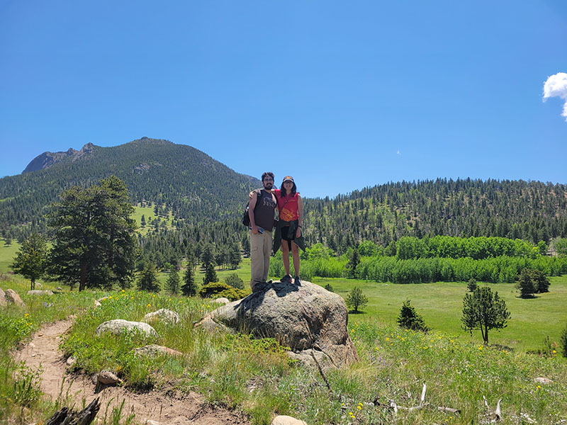 Paul and Jessie standing on a rock at Rocky Mountain National Park
