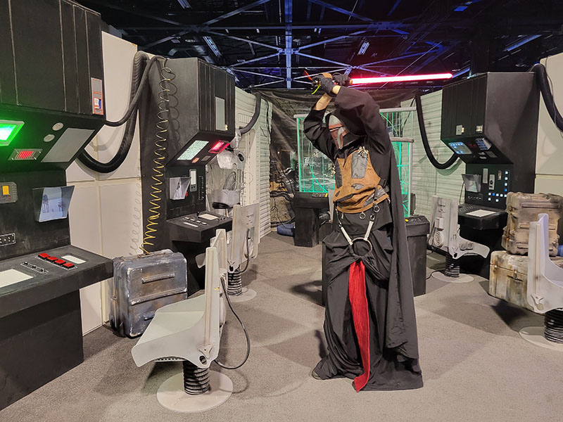 Paul in costume wielding a lightsaber