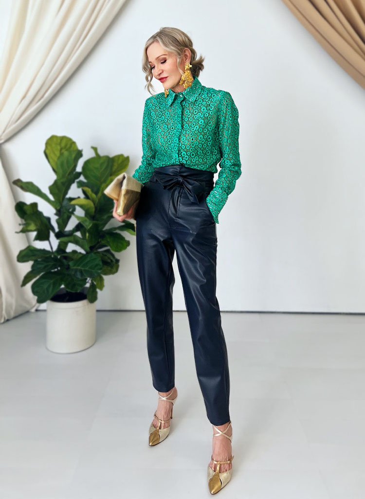woman wearing a green top and blue pants with gold heels