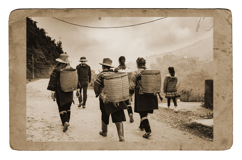 a group of rural residents walking along a path, facing away from the camera